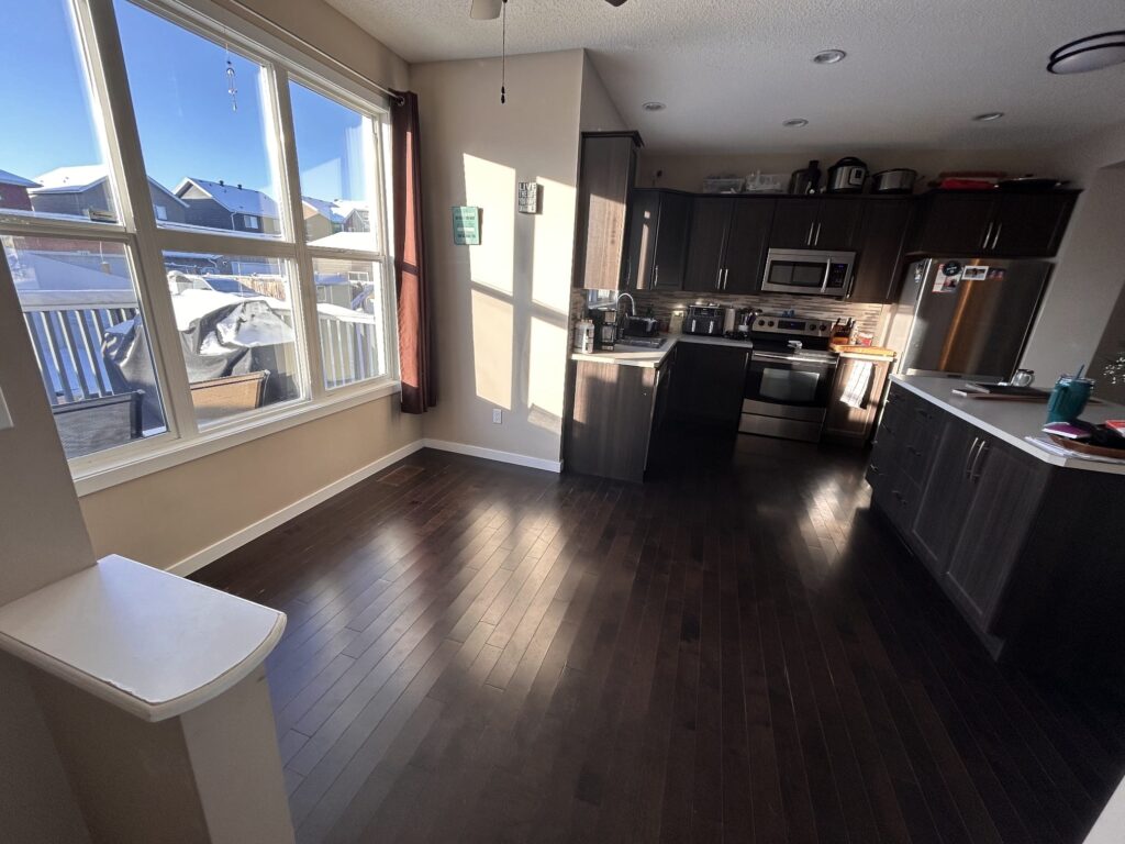 Finished dark hardwood carrying from the dining area through into the kitchen