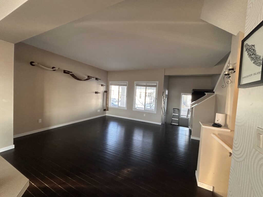 Finished dark hardwood running the length of an open living room toward the staircase